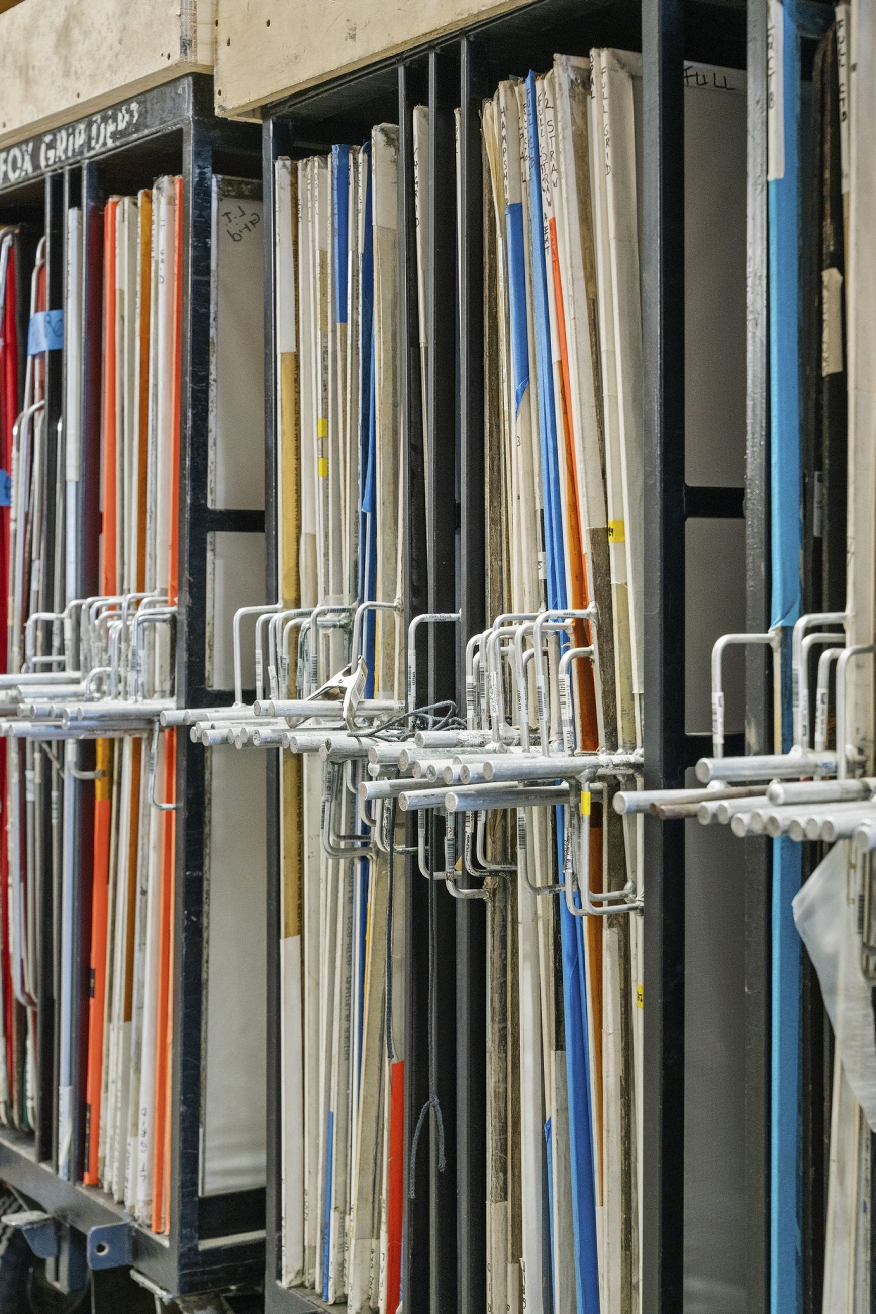 Numerous thick, coiled gray ropes hanging from shelves alongside wooden pulleys.