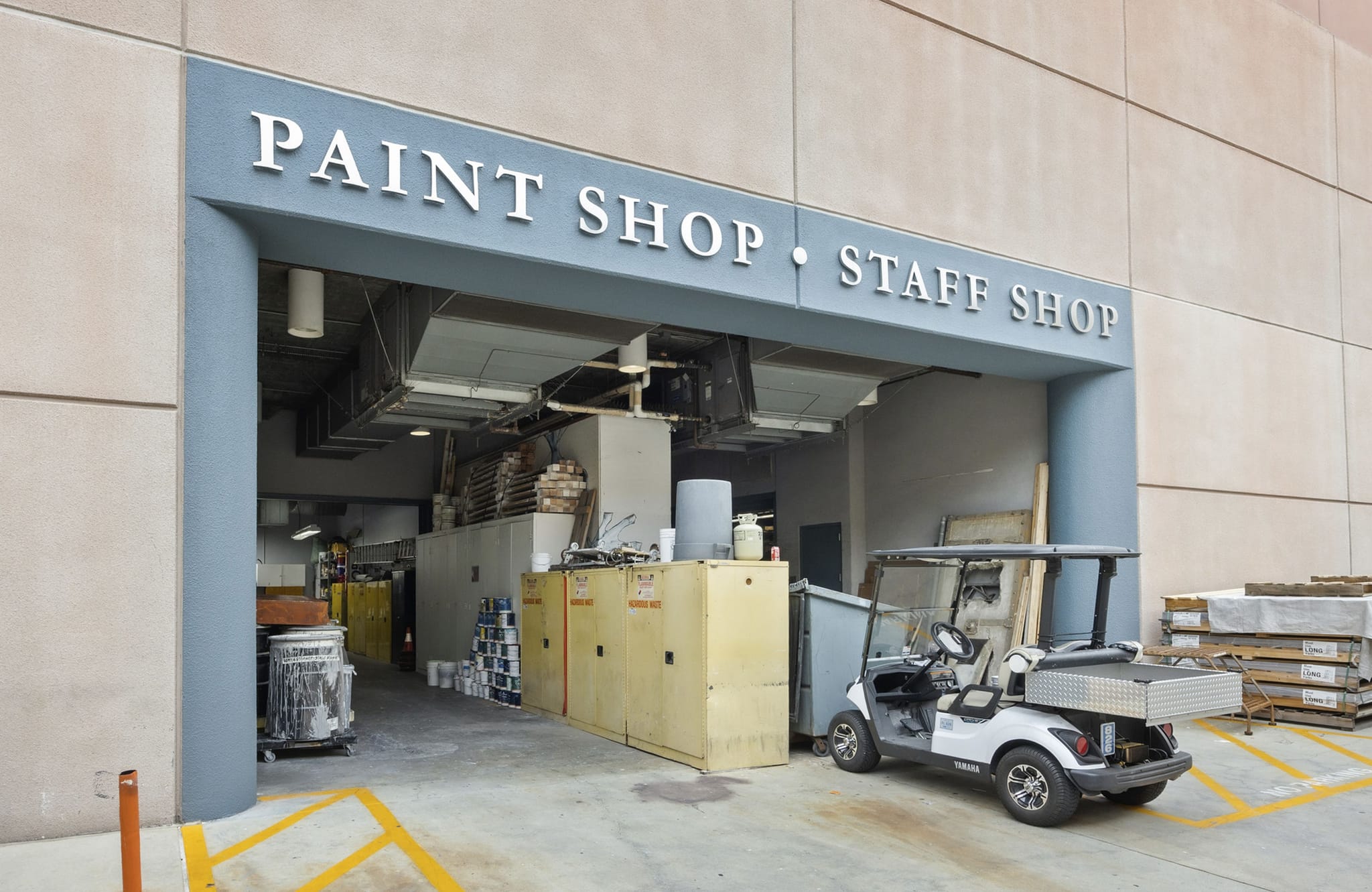 Entrance to a "Paint Shop" and "Staff Shop" with a golf cart parked outside.