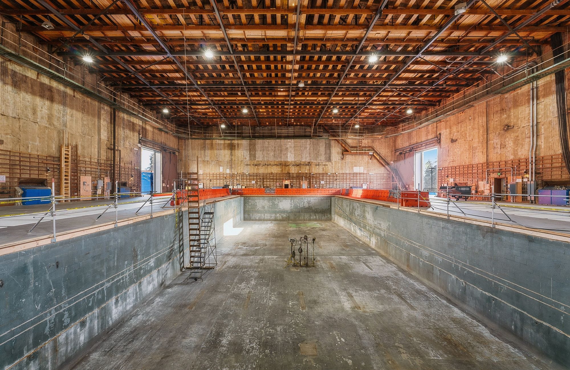 Large industrial hall with an empty, deep rectangular concrete pit.