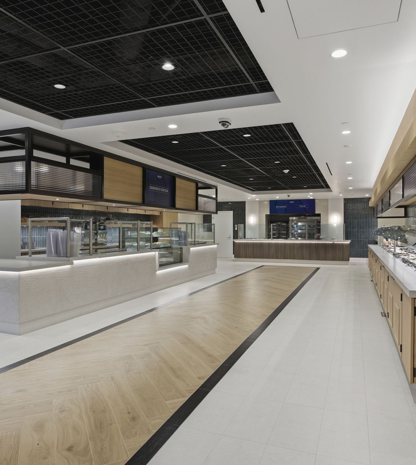 A lively co-working space and bar where people work on laptops and socialize under an industrial ceiling.