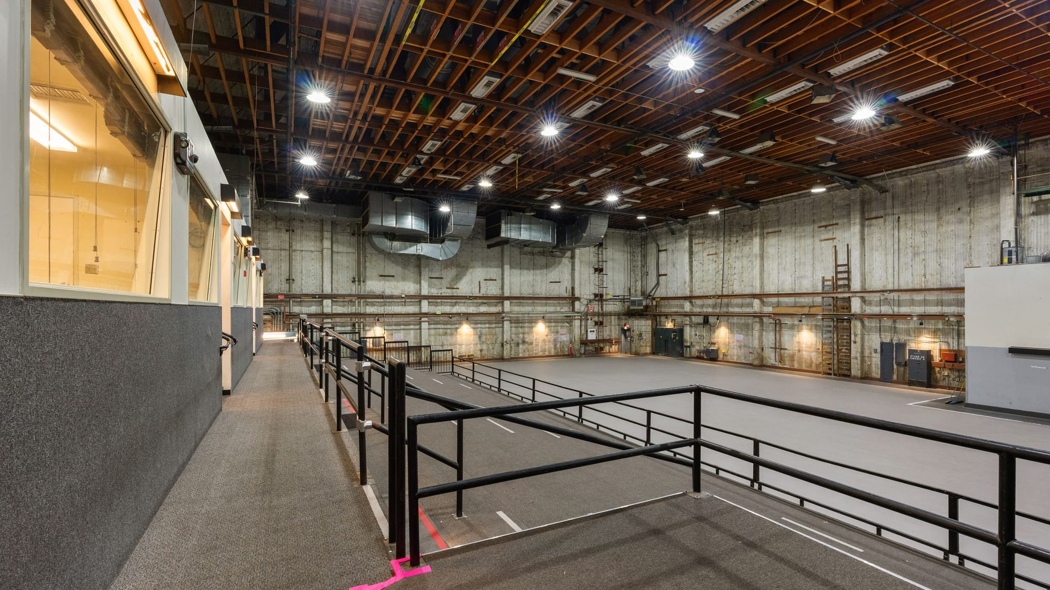 Empty sound stage with an elevated viewing platform and a high wooden beam ceiling.