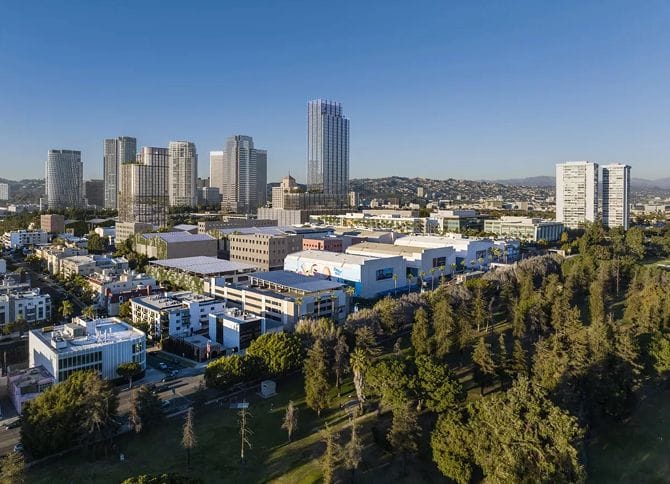 Aerial view of a modern cityscape with skyscrapers, urban buildings, and a large green park.