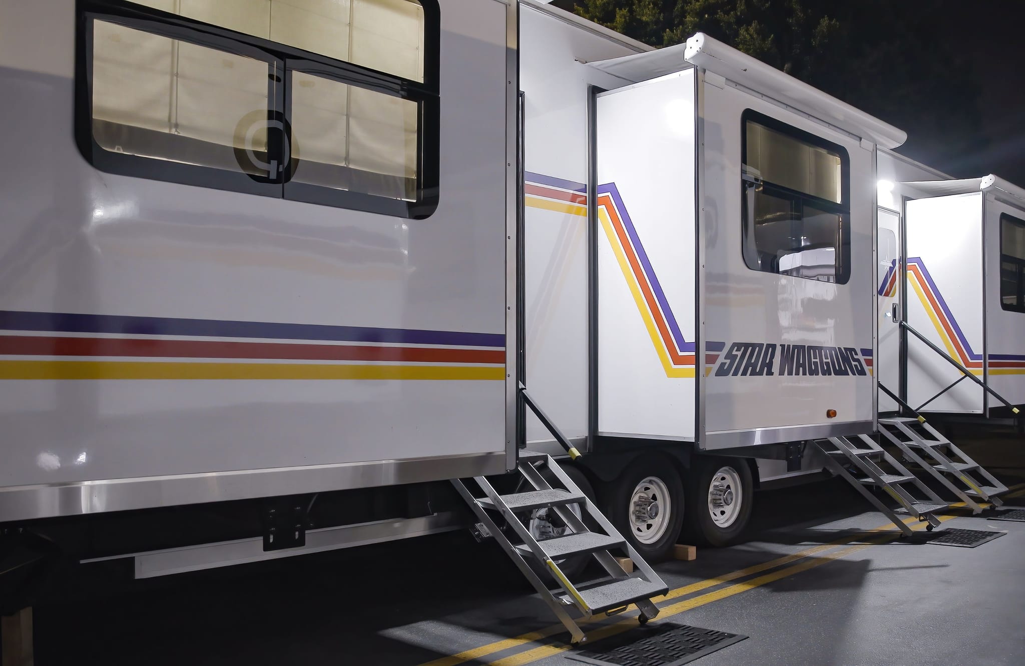 White trailers with "STAR WAGGONS" branding and retro stripes at night.