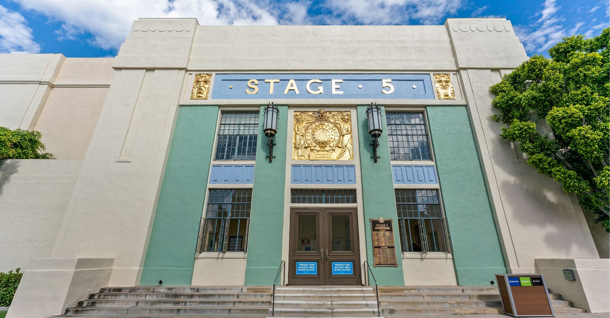 Art Deco building facade for "STAGE 5" with gold lettering and light green panels.