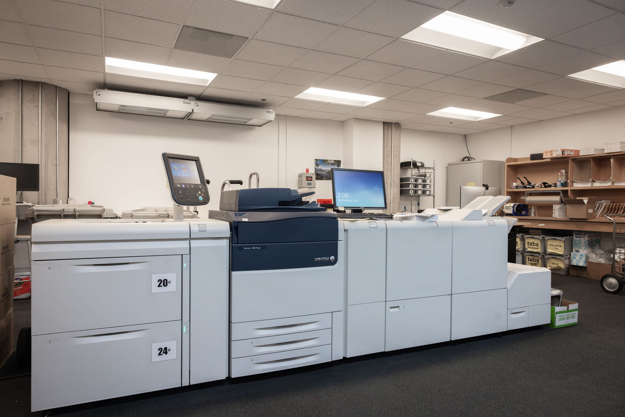 A large white and dark blue digital printing press in a production room.