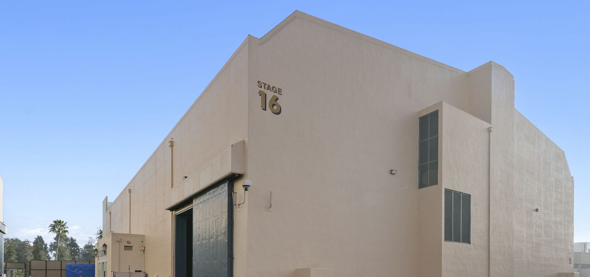 A light brown soundstage building labeled "STAGE 16" with a large dark sliding door.
