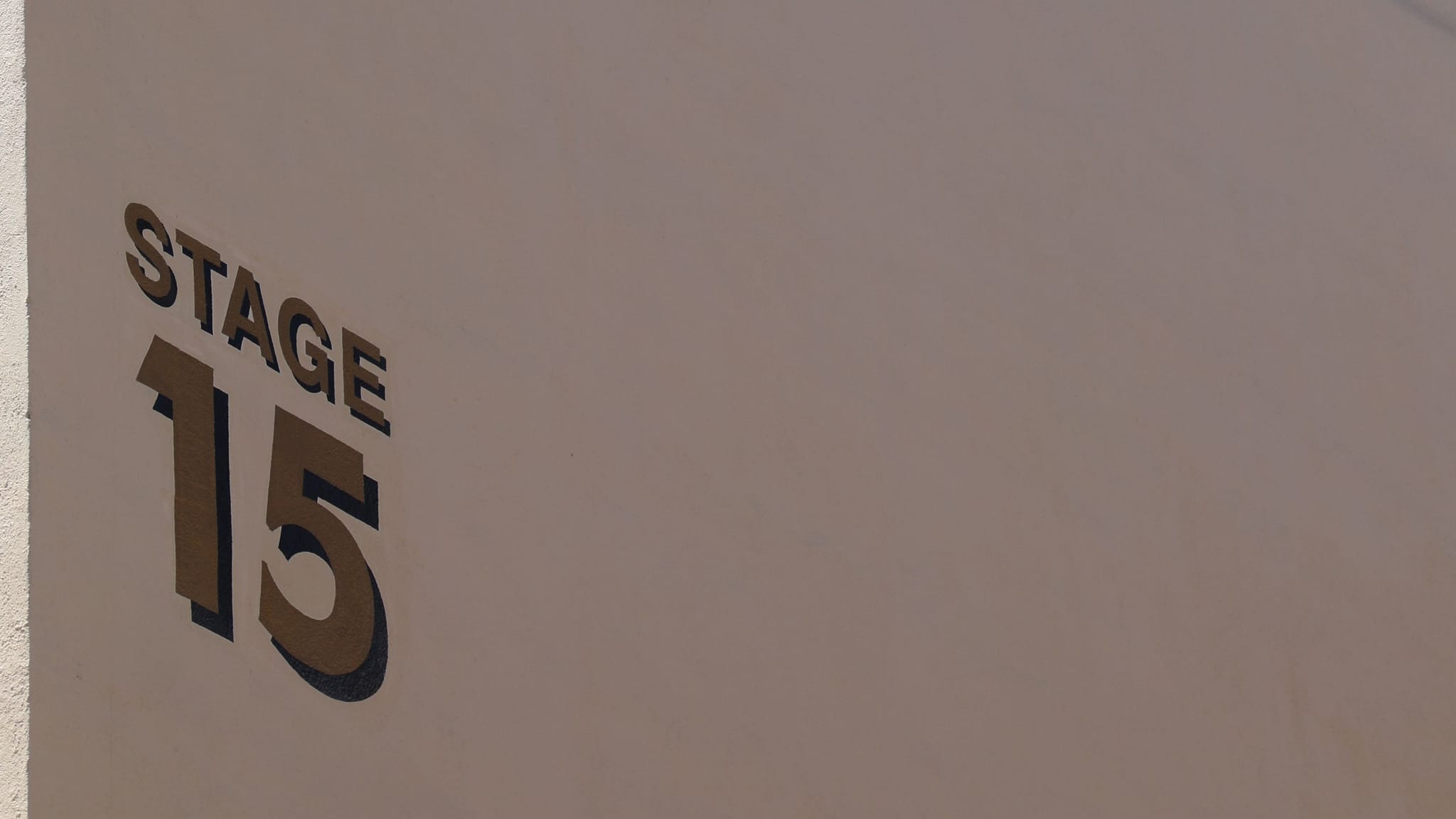 STAGE 15 sign on a light brown wall.