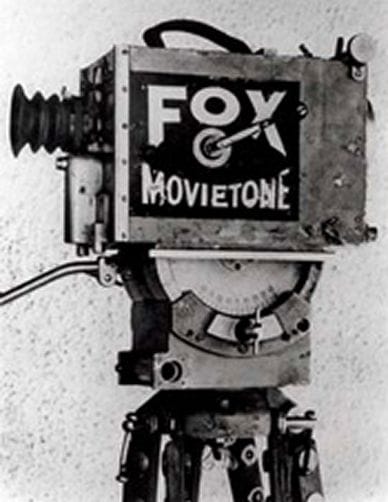 A vintage Fox Movietone film camera mounted on a tripod.