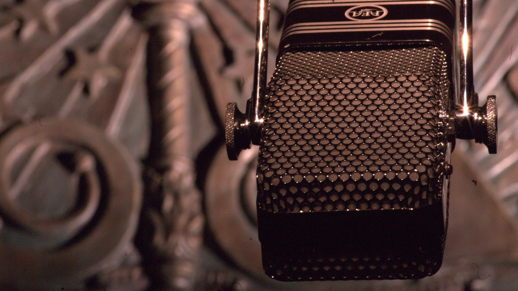 Close-up of a vintage RCA ribbon microphone with a blurred ornate background.