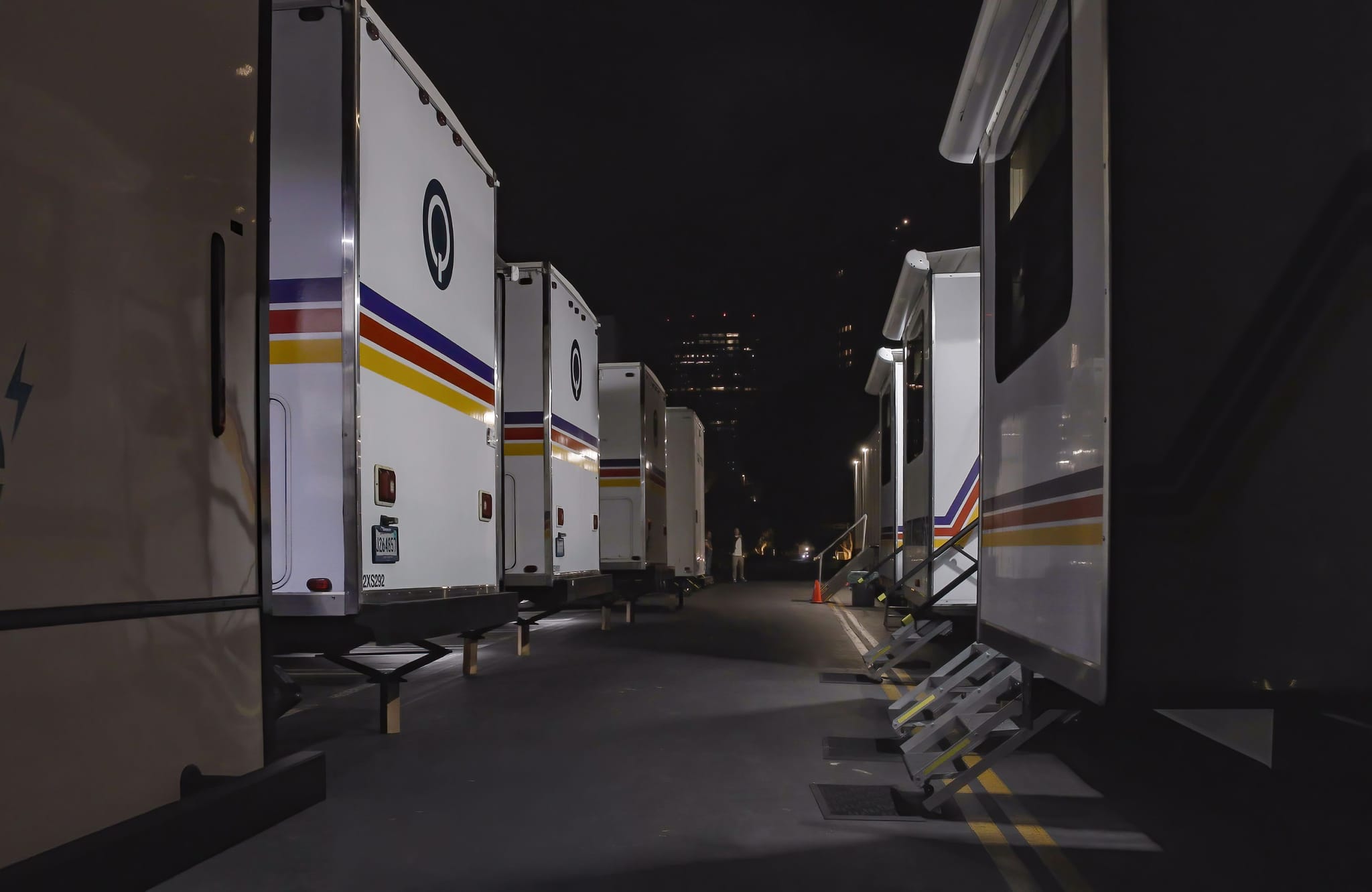 Star Waggons trailers with colorful stripes parked at night.
