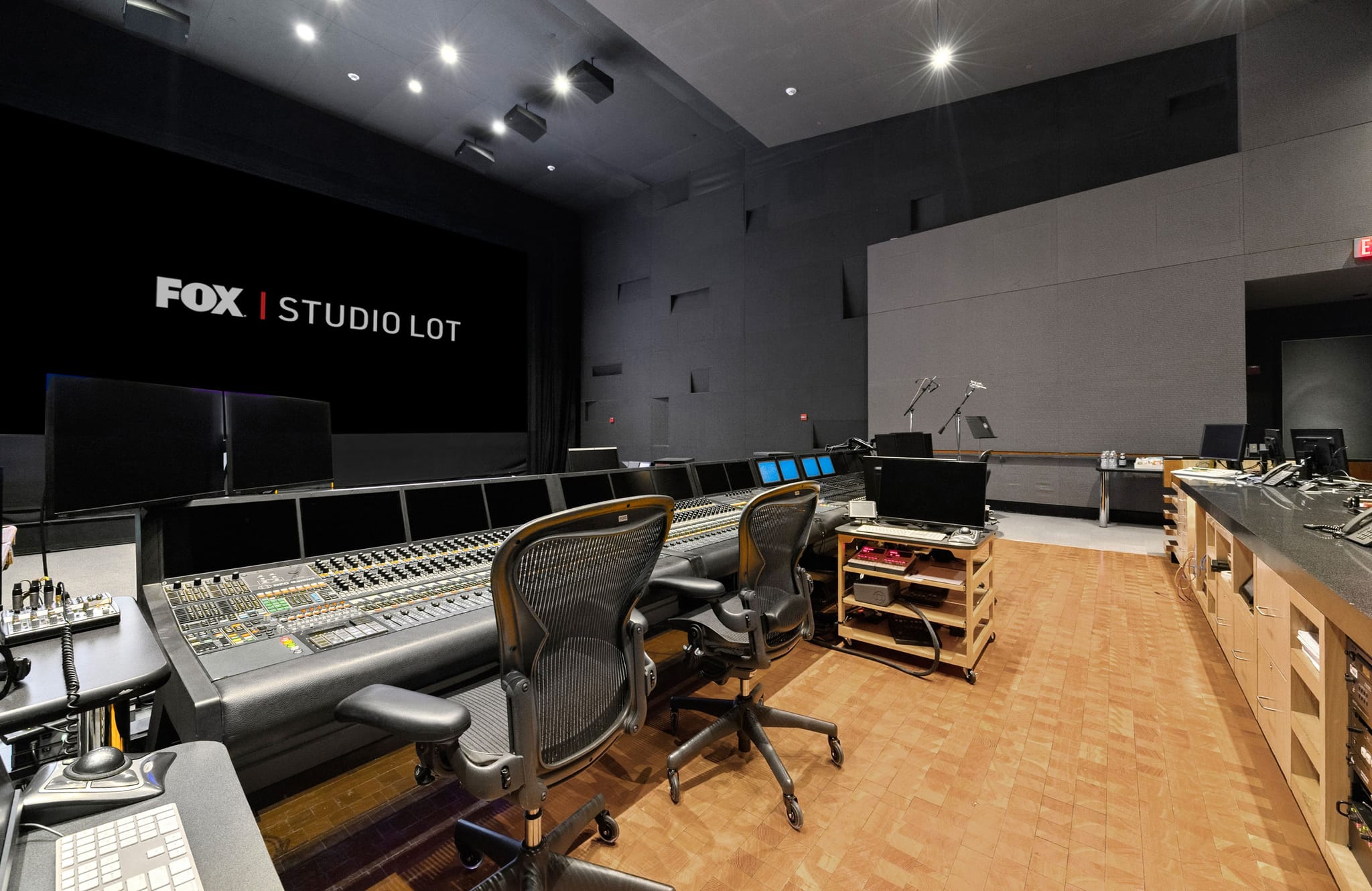 A professional sound mixing studio with a large console and a screen displaying "FOX | STUDIO LOT."