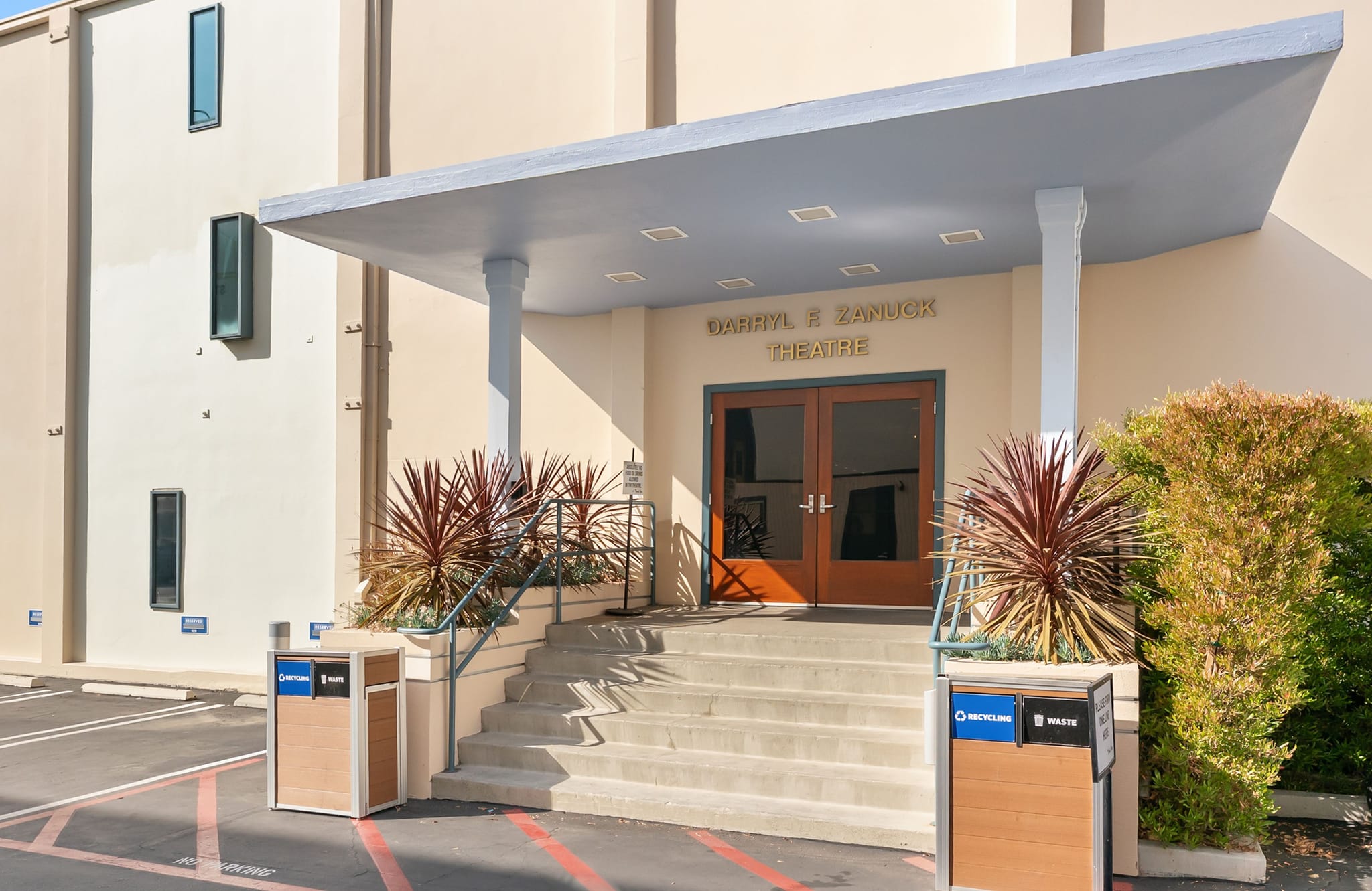 Front entrance of the Darryl F. Zanuck Theatre with steps, double doors, and an awning.
